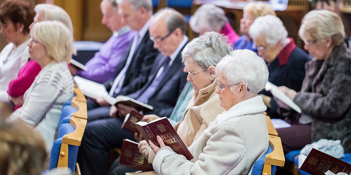 Members of the congregation reading the Bible